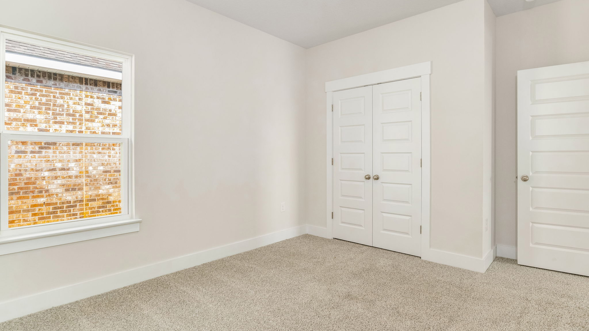 The Oakley floorplan guest bedroom one with carpet throughout