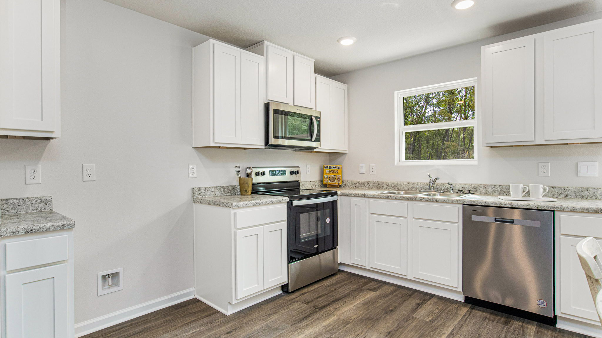 The Allanton floorplan kitchen with white shaker cabinets and Formica countertops