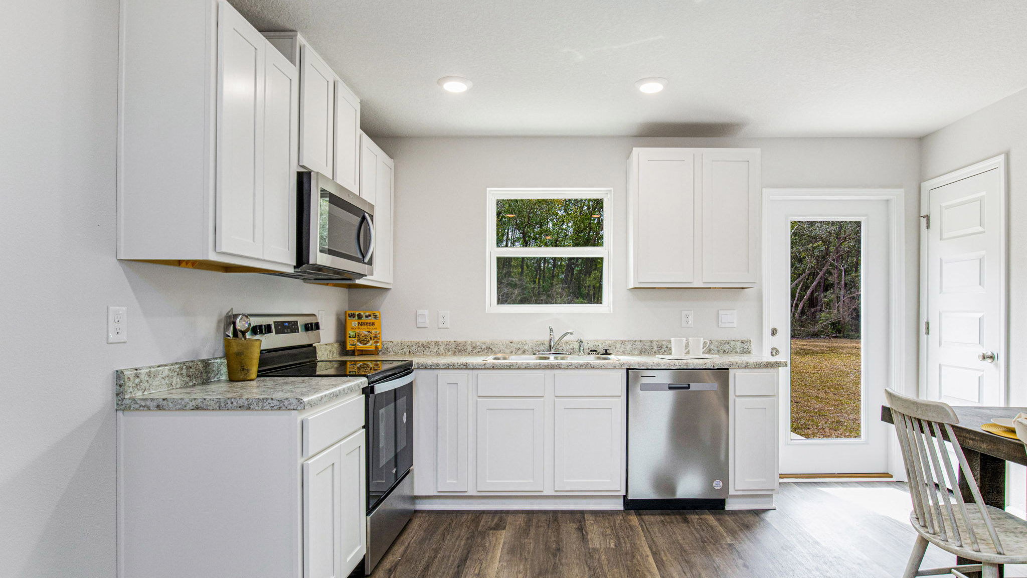 The Allanton floorplan kitchen with white shaker cabinets and Formica countertops