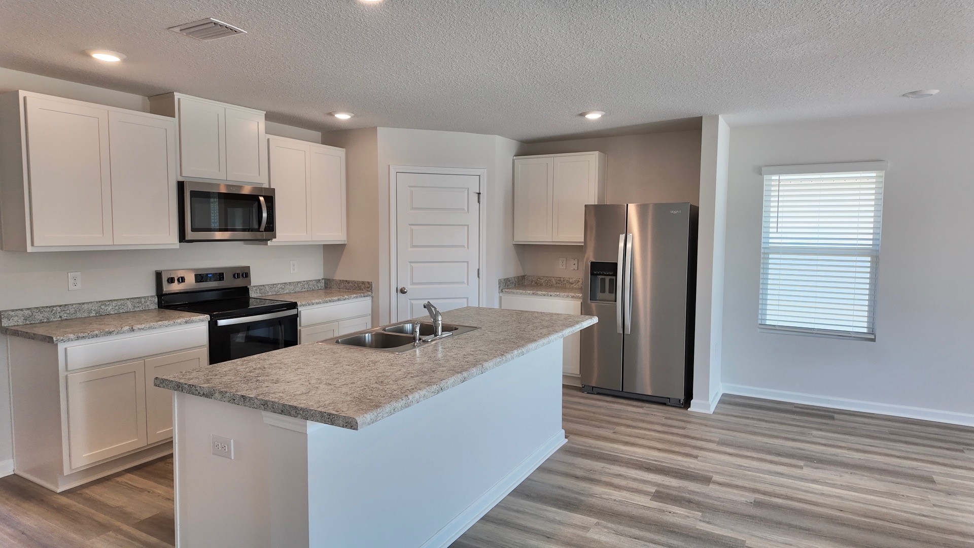 The Lismore floorplan kitchen with white shaker cabinets and Formica countertops