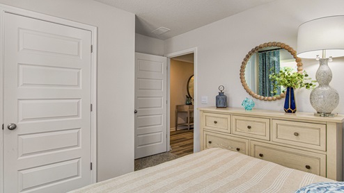 The Highlands Lakeside Model Home guest bedroom three door view