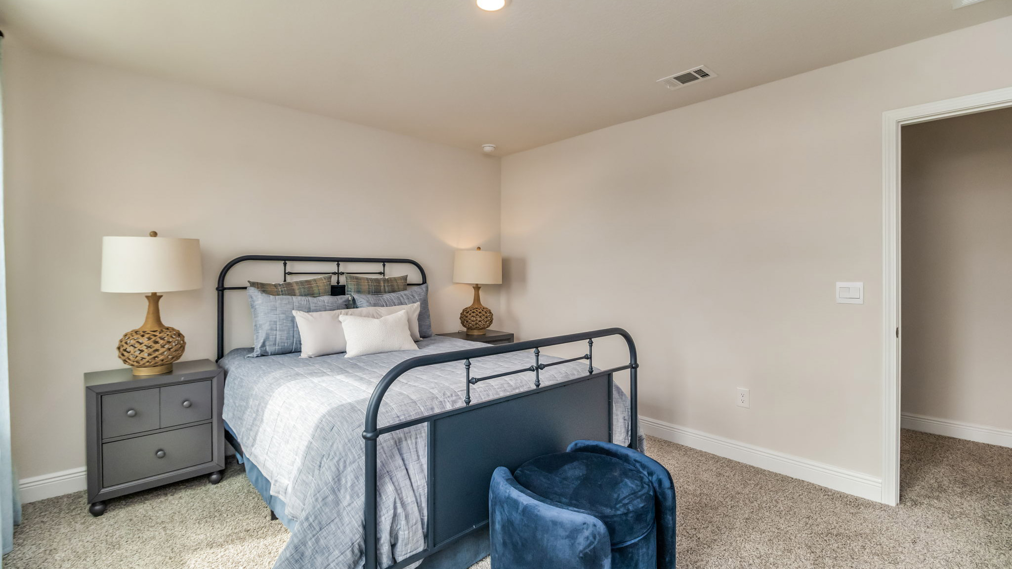 The Belfort floorplan guest bedroom one with two windows and carpet throughout