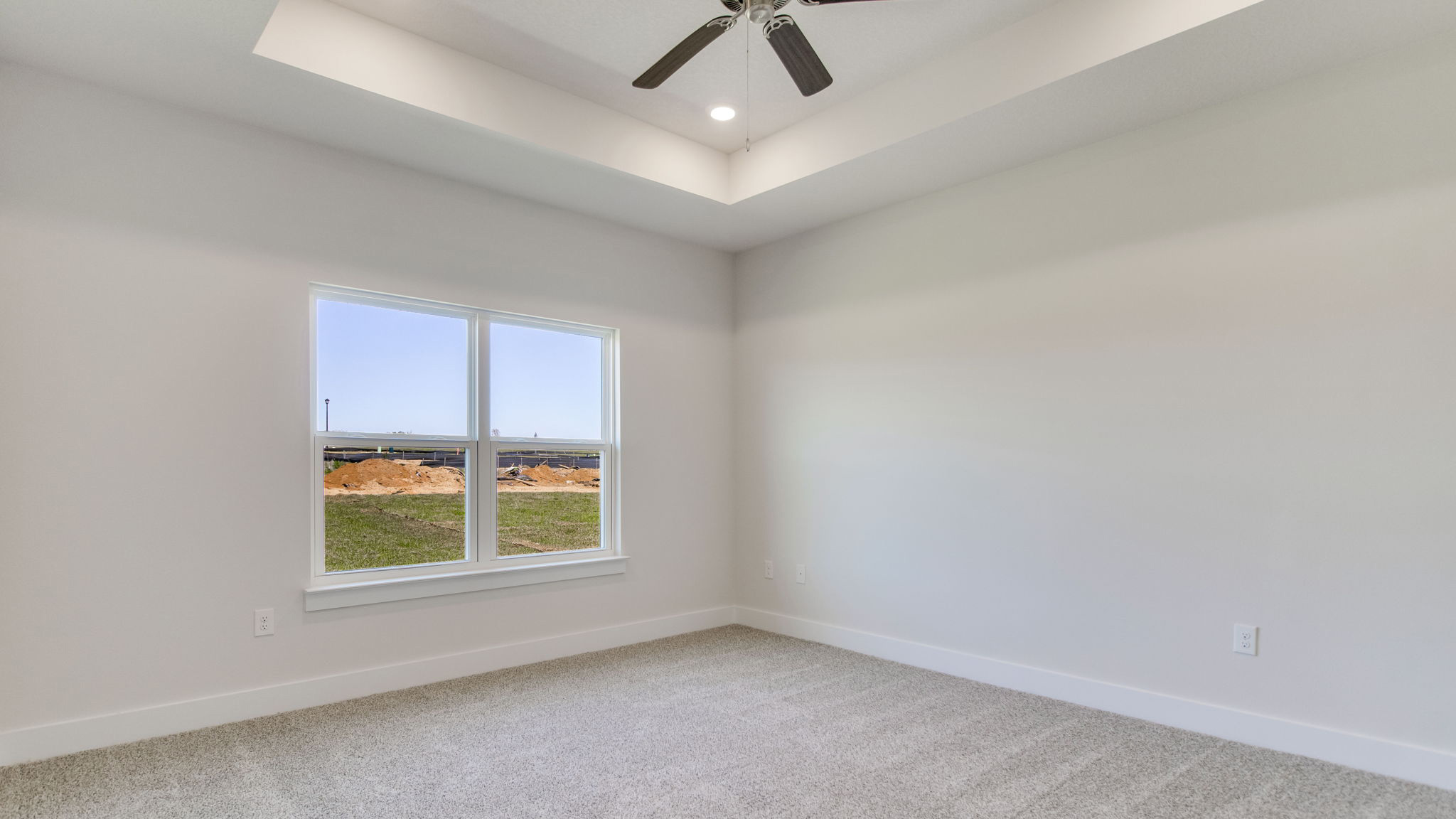 The Lamar floorplan primary bedroom with tray ceiling and carpet throughout