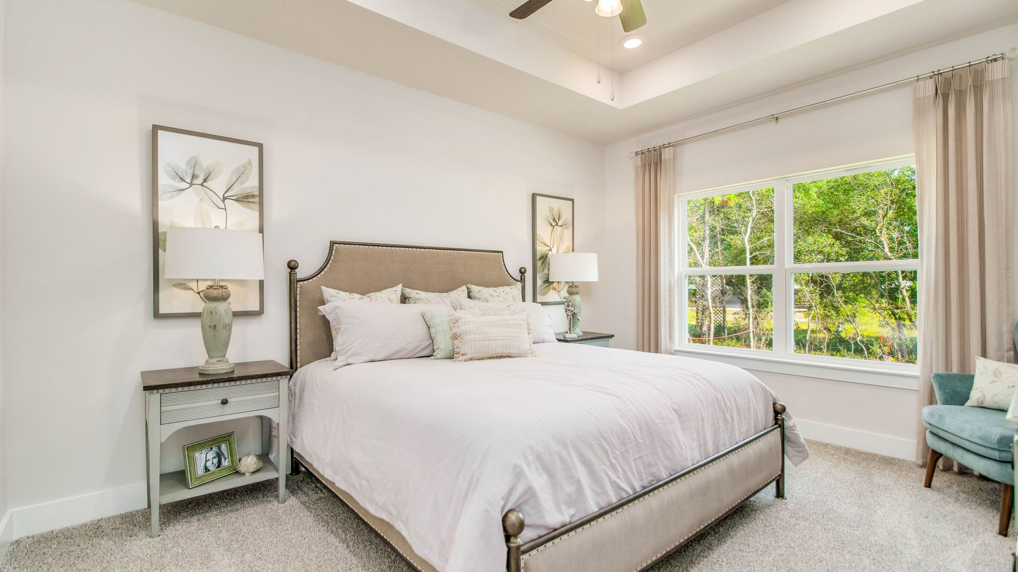 The Rhett floorplan primary bedroom with carpet flooring and tray ceilings