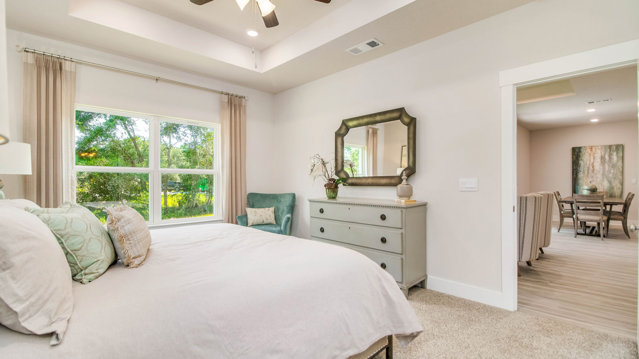 The Rhett floorplan primary bedroom with carpet flooring and tray ceilings