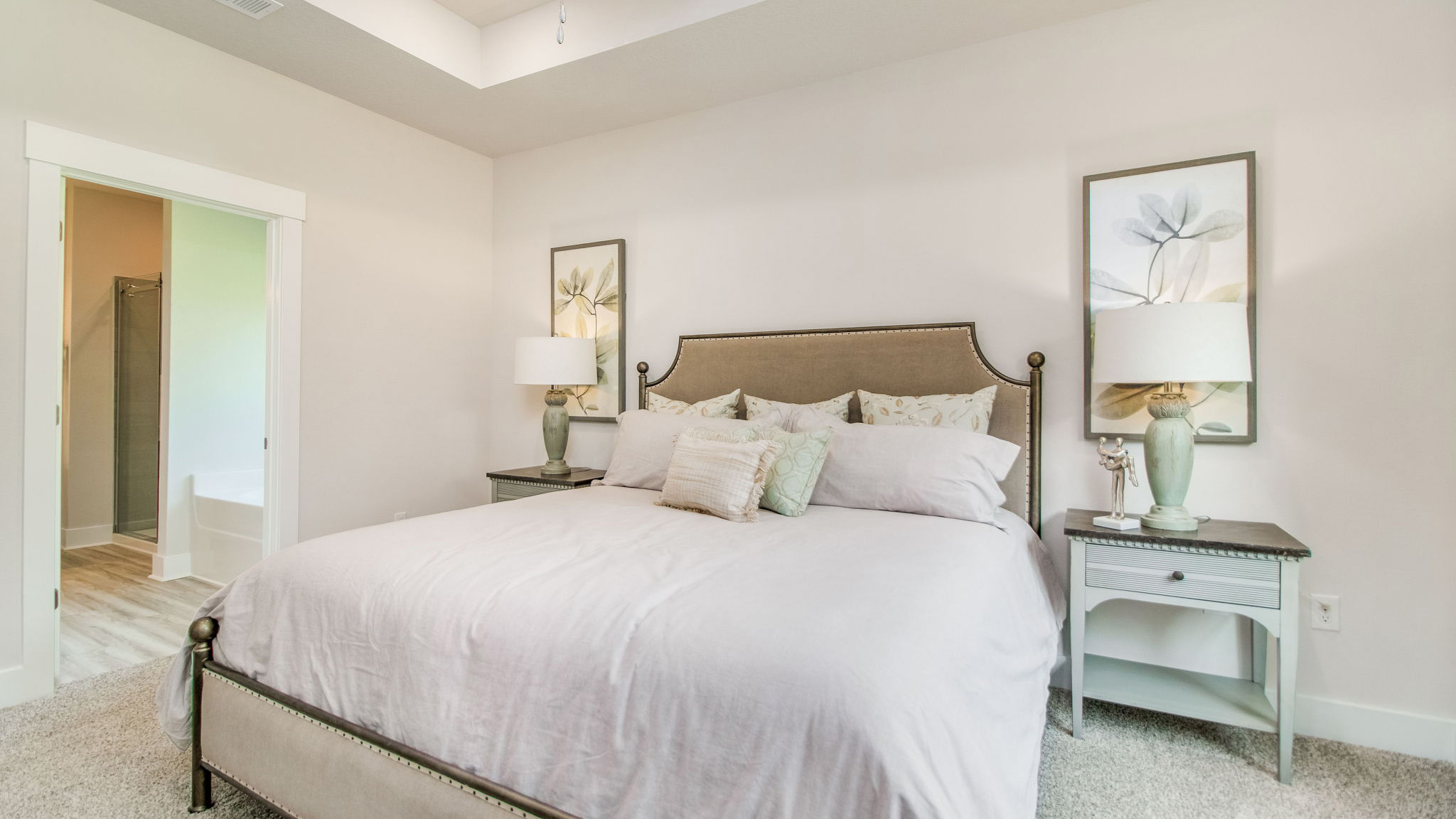 The Rhett floorplan primary bedroom with carpet flooring and tray ceilings