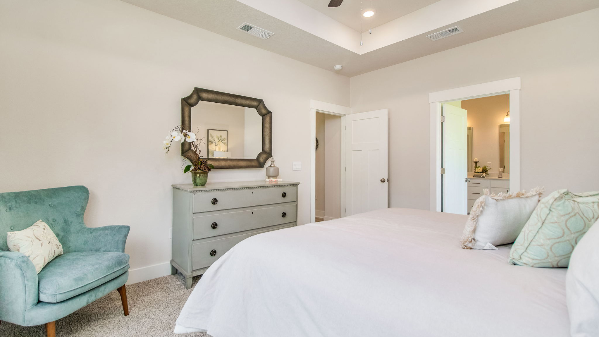 The Rhett floorplan primary bedroom with carpet flooring and tray ceilings