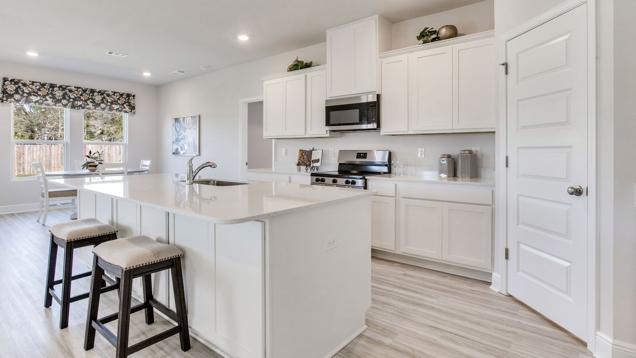 The Camden floorplan kitchen with white shaker cabinets and quartz countertops