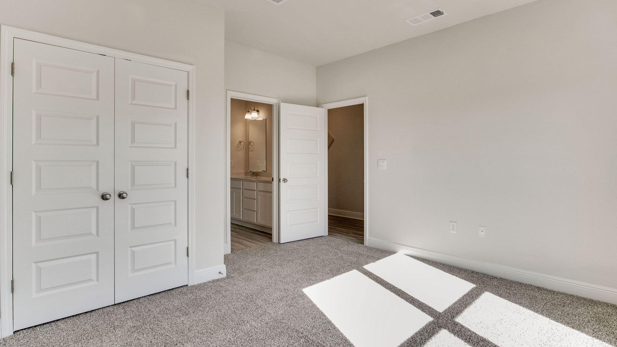 The Camden floorplan guest bedroom two with carpet throughout