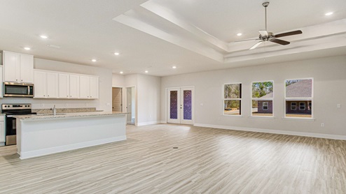 The McKenzie floorplan open concept living room and kitchen with trey ceilings