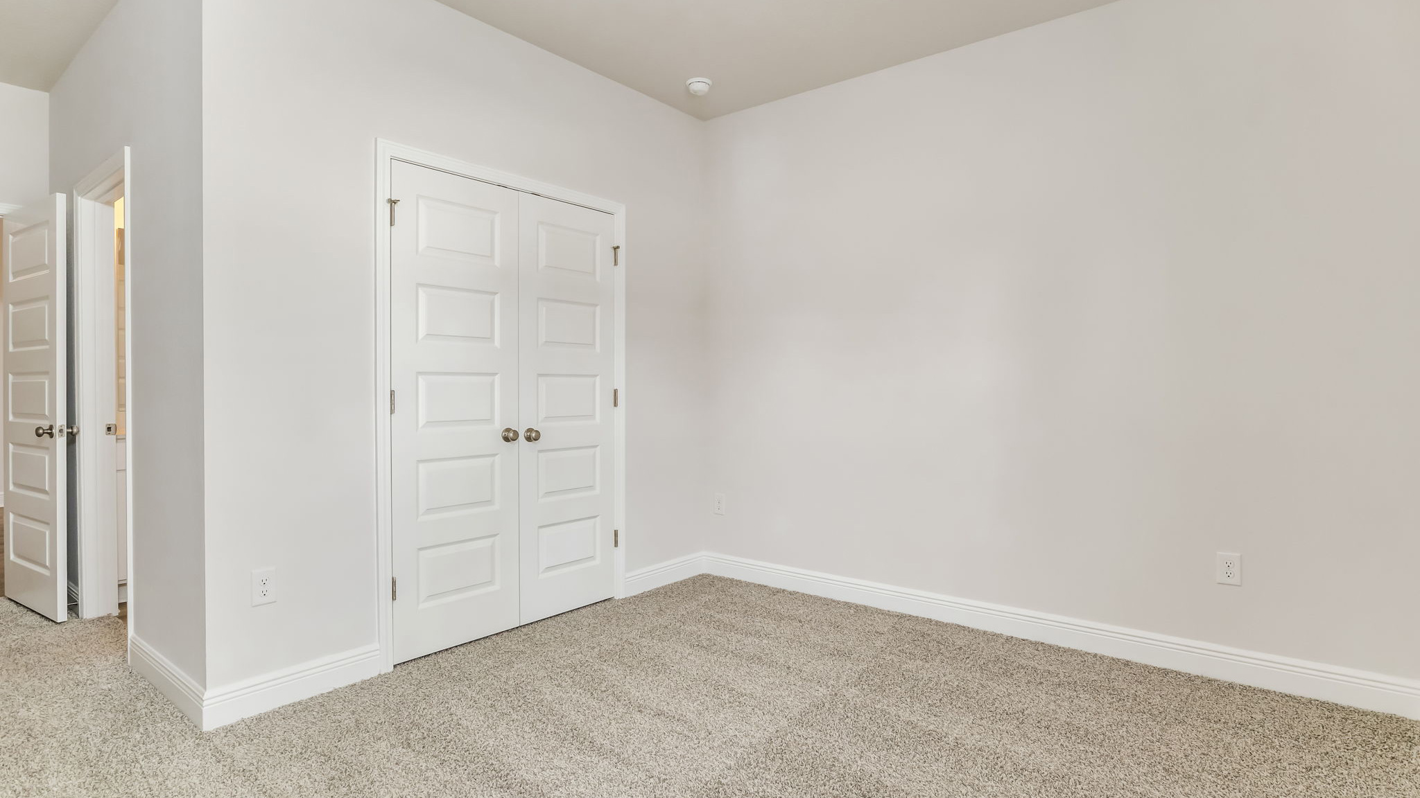 The Madison floorplan guest bedroom one with carpet throughout