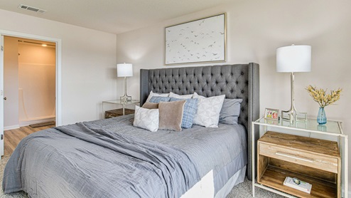 The Cali primary bedroom with primary bathroom entry view