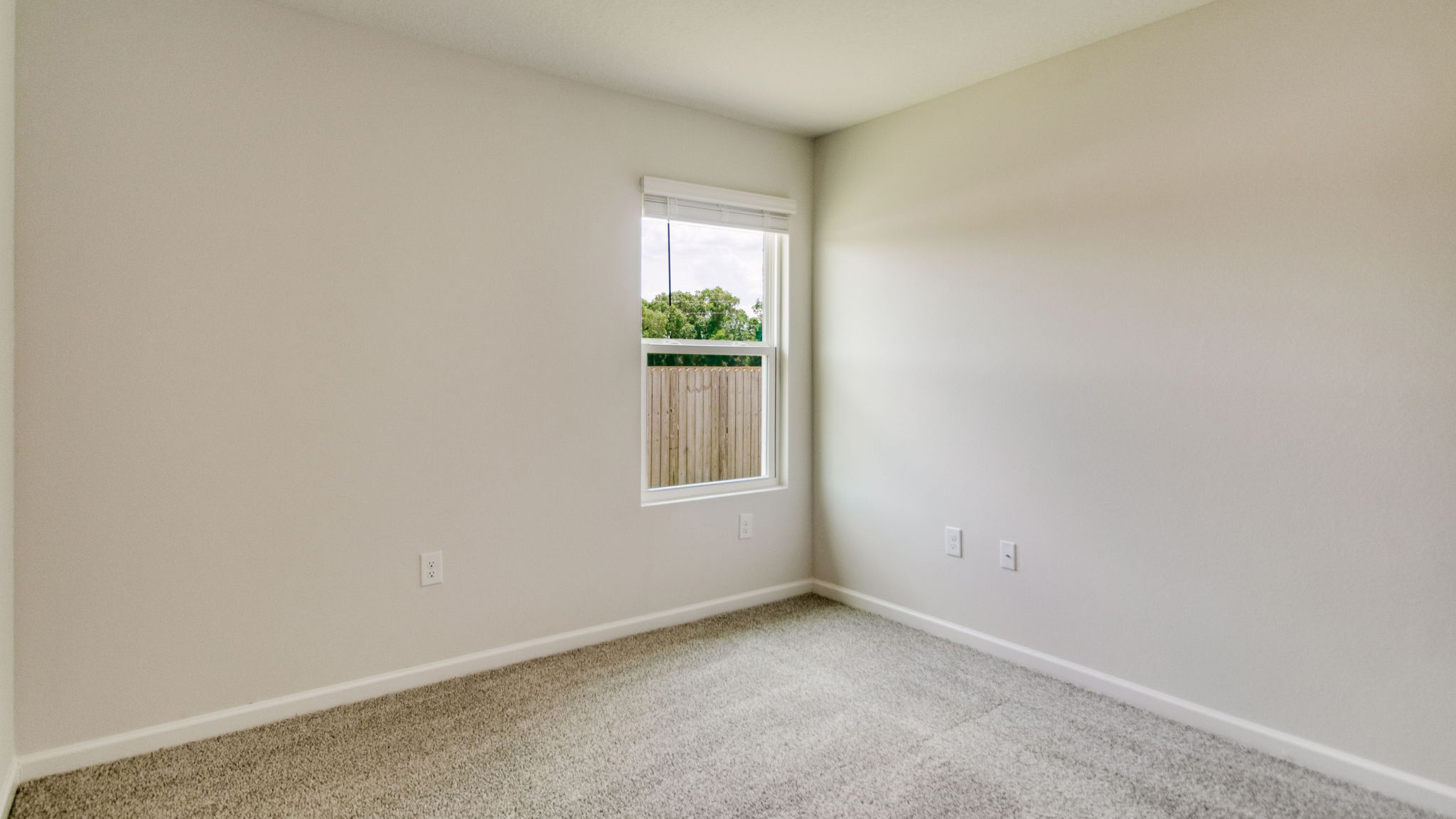 The Sawyer floorplan guest bedroom one with carpet throughout