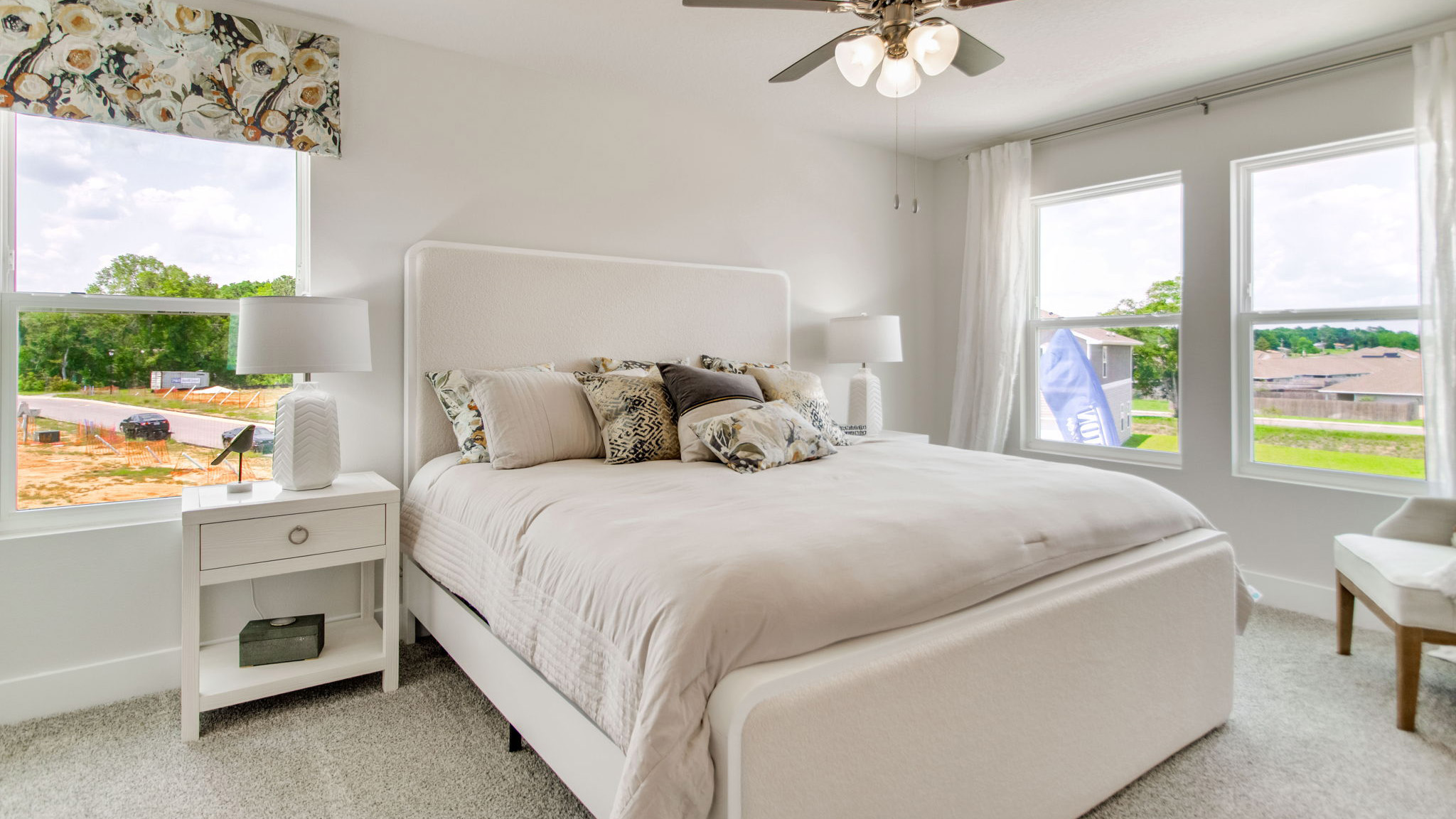 The Palm floorplan primary bedroom with three windows and natural lighting
