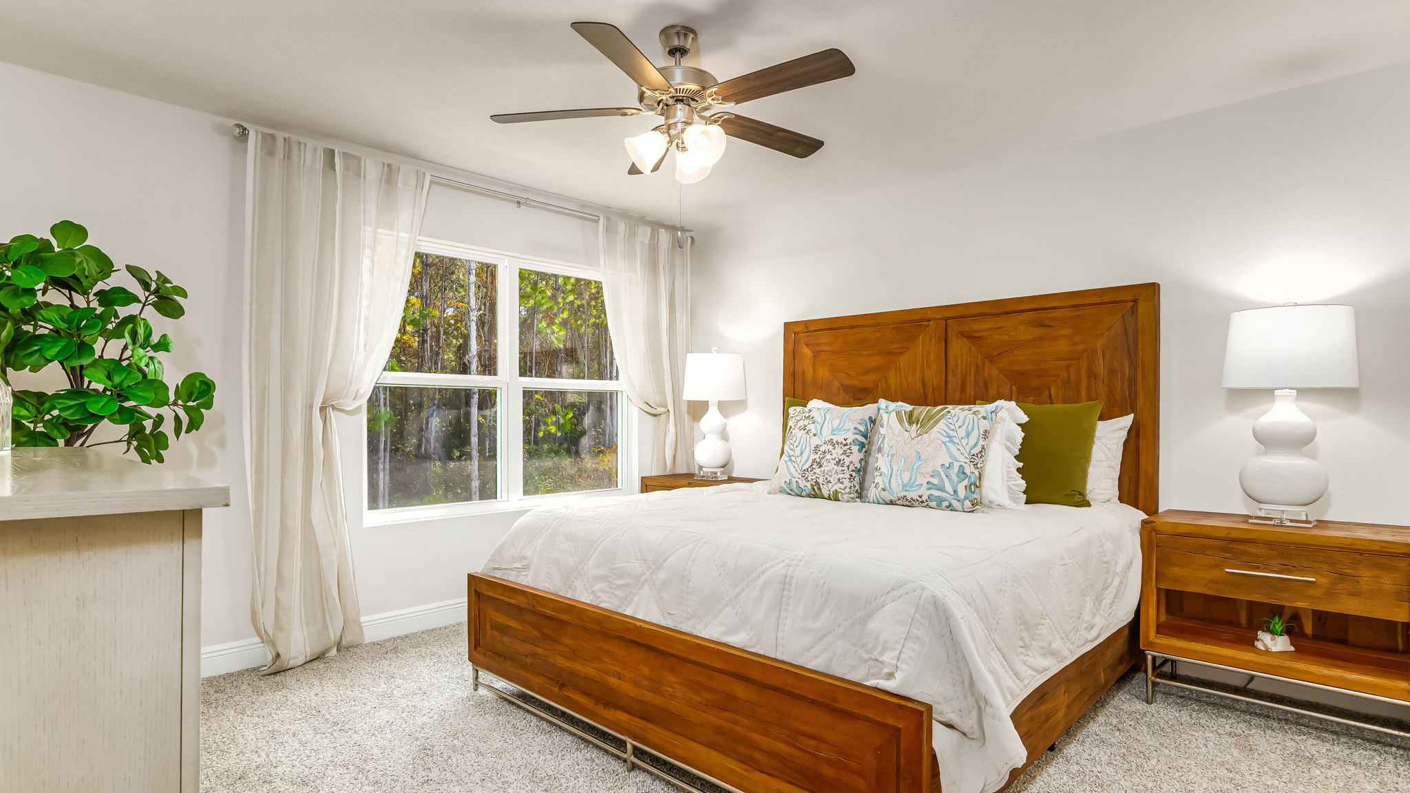The Sabal floorplan primary bedroom with large window and carpet throughout