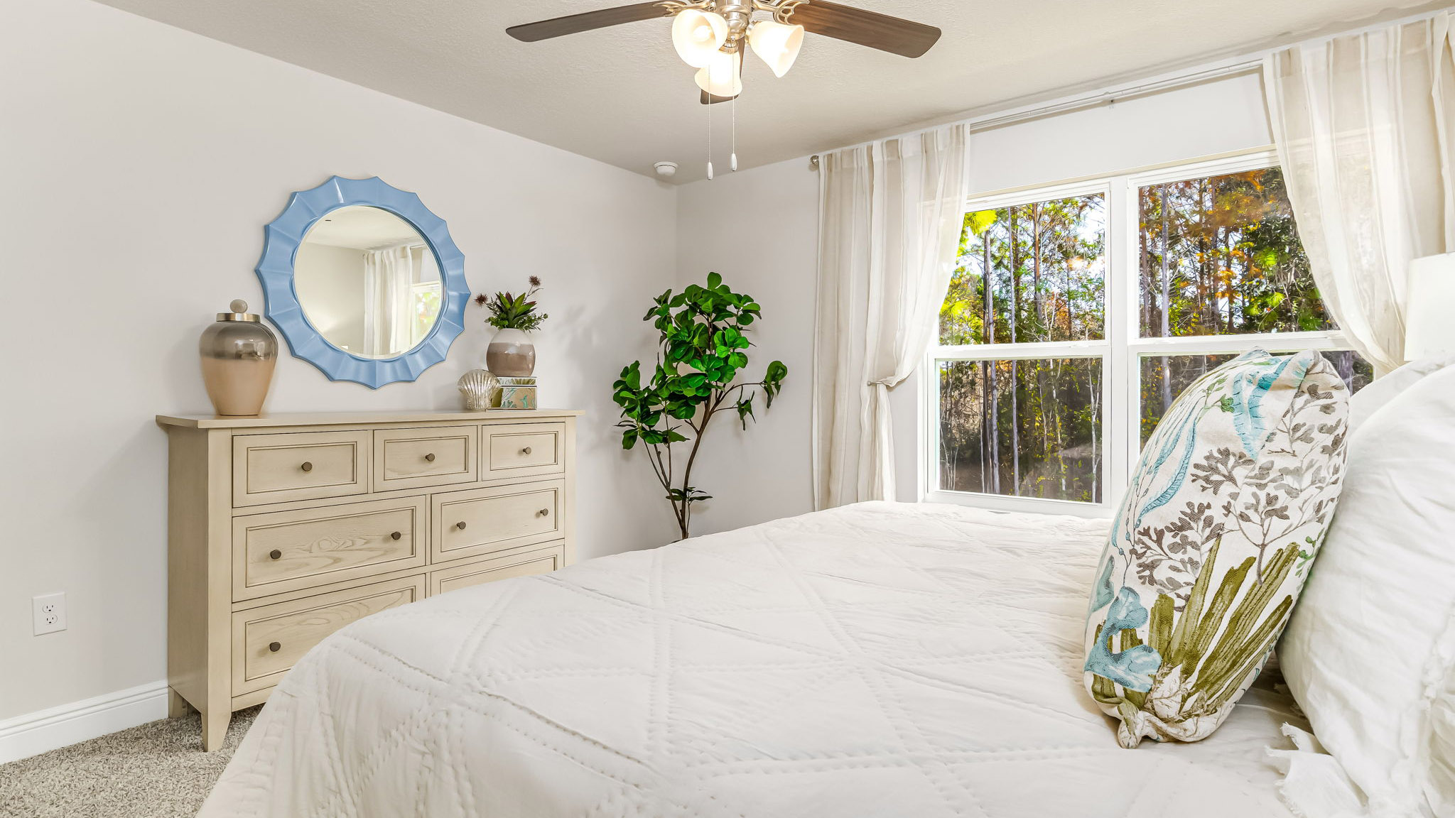 The Sabal floorplan primary bedroom with large window and carpet throughout