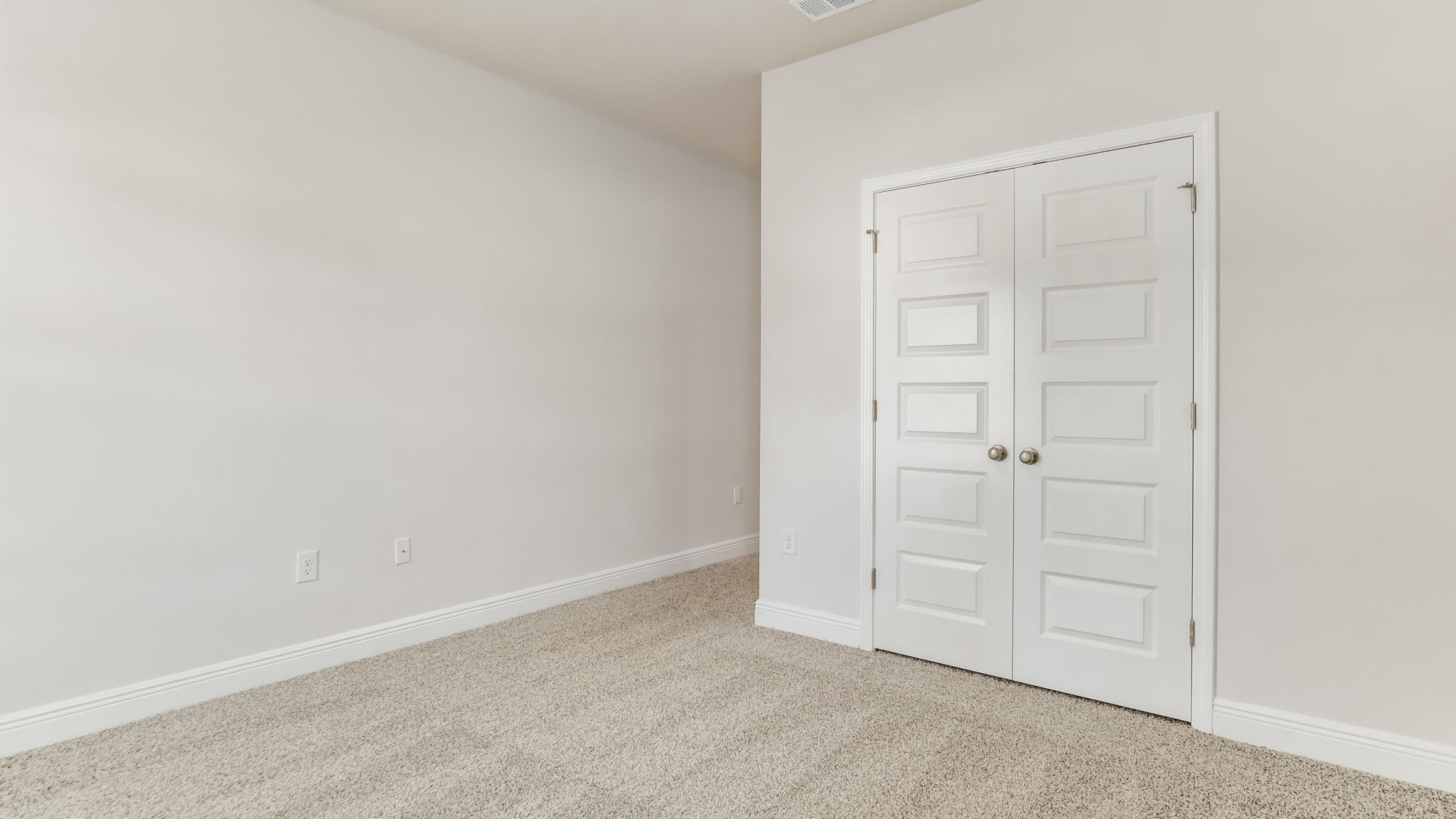 The Madison floorplan guest bedroom one with carpet throughout