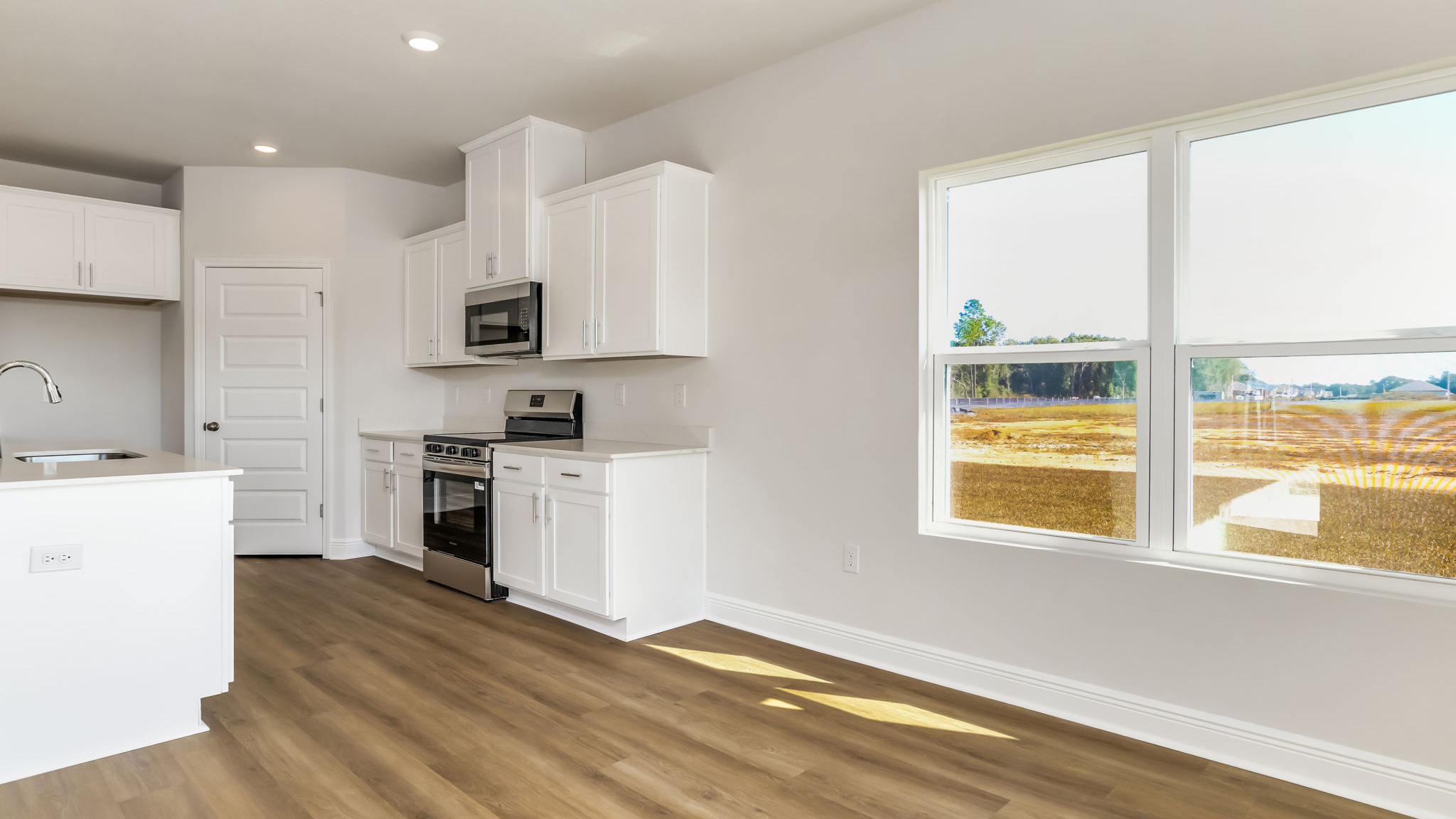 The Madison floorplan kitchen with white shaker style cabinets thorughout