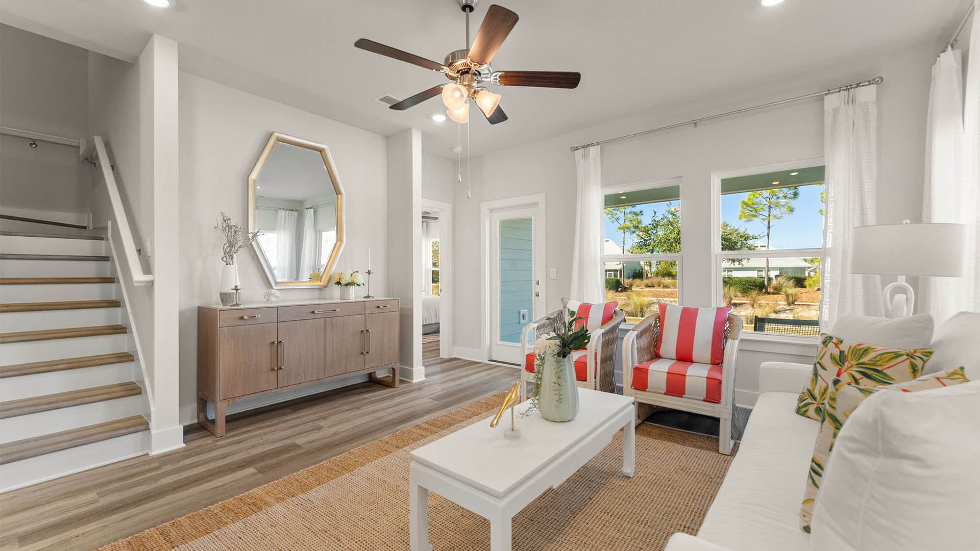 Living room with ceiling fan and EVP flooring and back door and stairs.