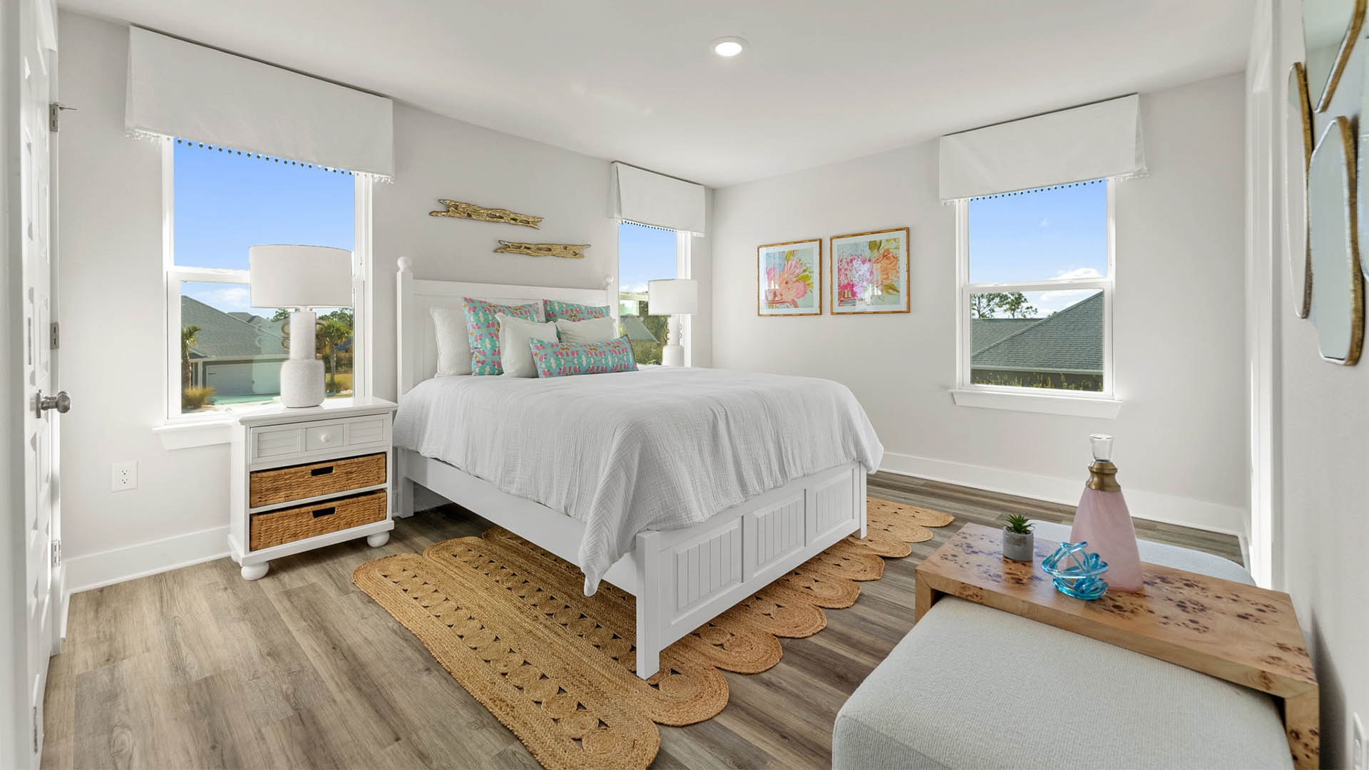 Primary bedroom with EVP flooring with ceiling fan and window and bathroom entrance.
