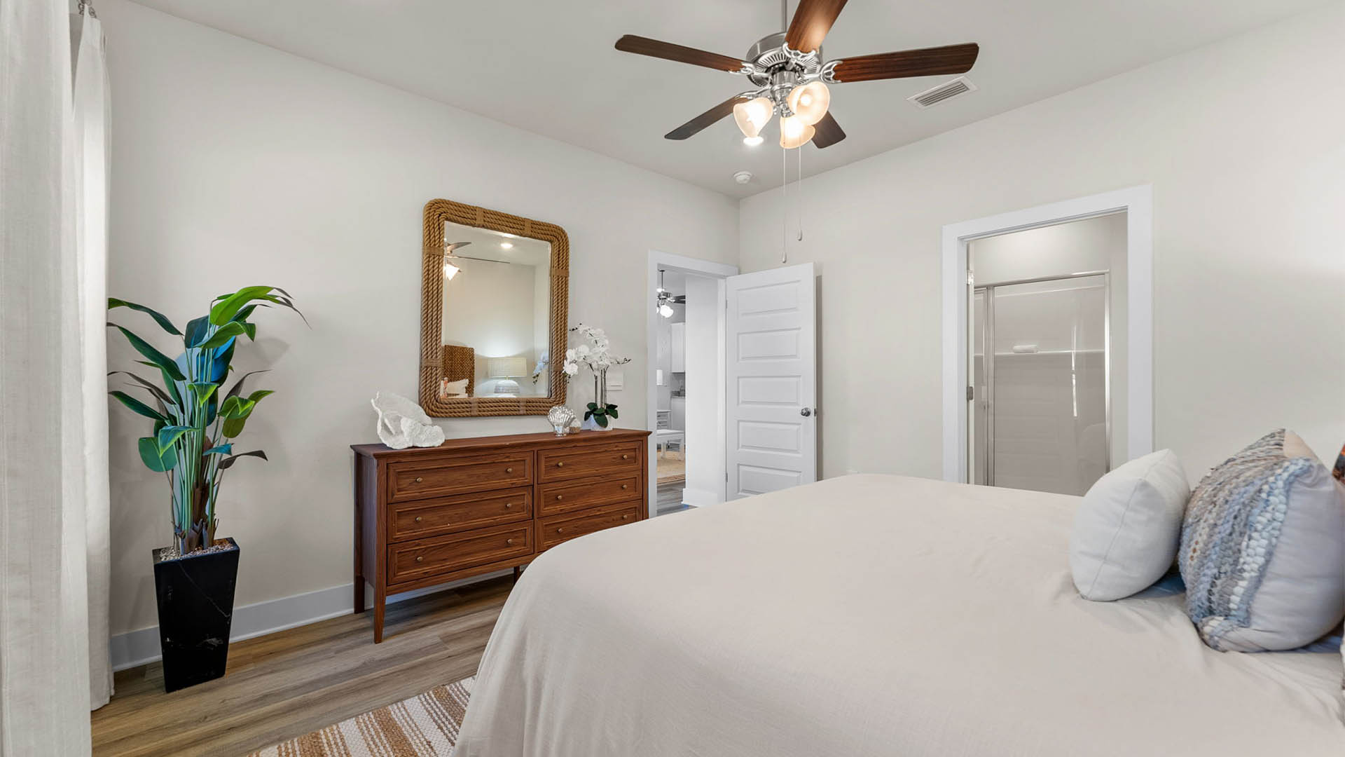 Primary bedroom with EVP flooring with ceiling fan and bathroom entrance.
