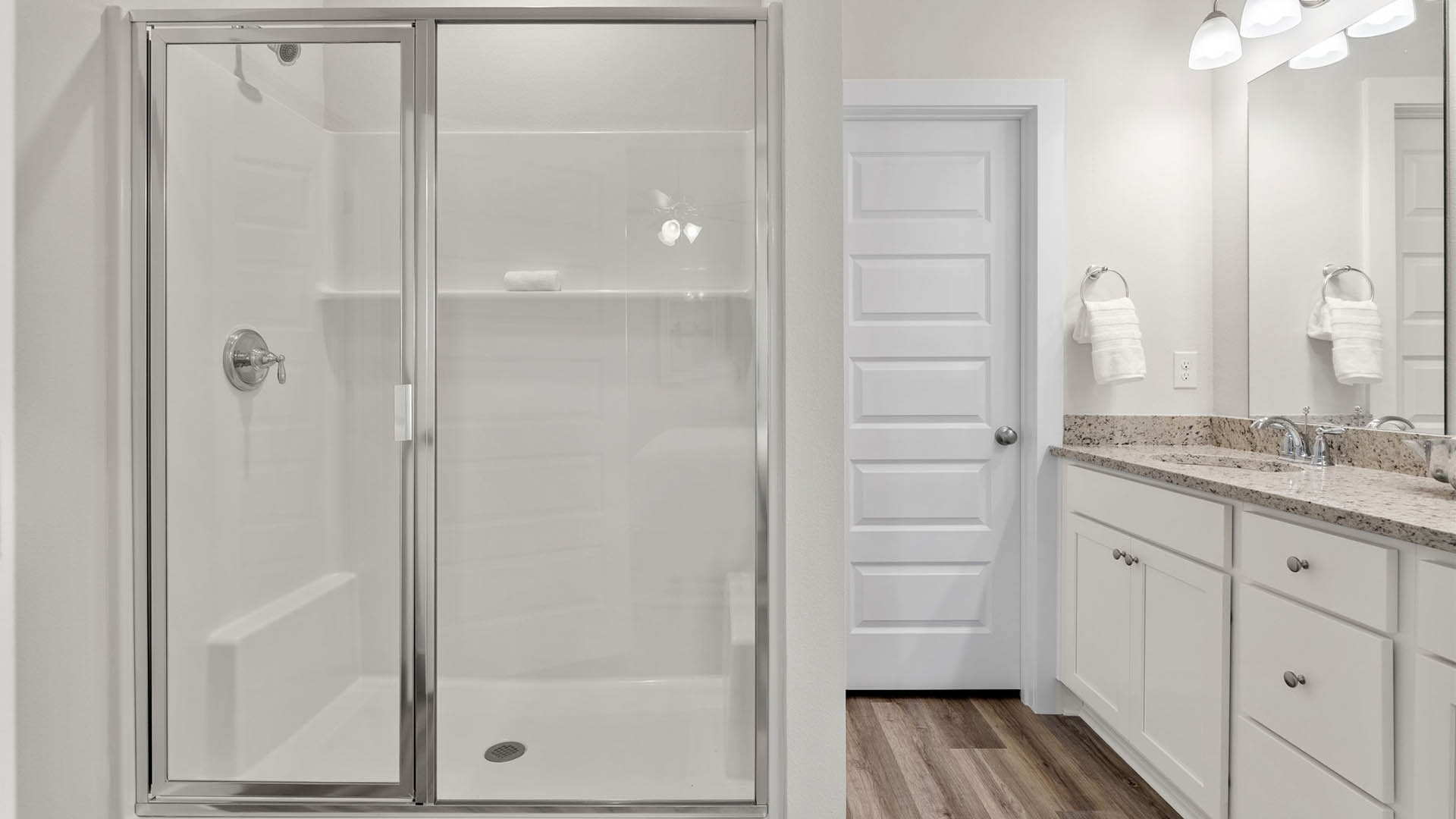 Primary bathroom with double vanity granite countertops and white cabinets and shower and closet with EVP flooring.