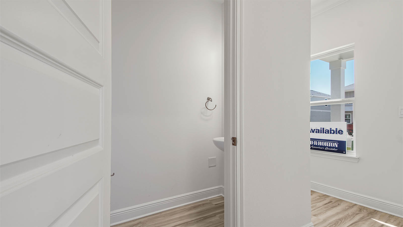 Half bathroom with sink and mirror and hallway.