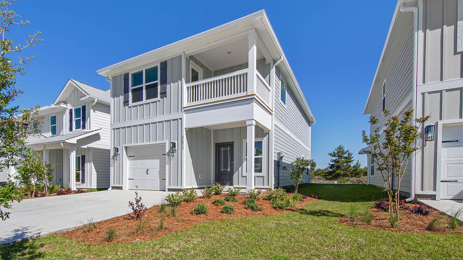 Monroe floor plan at WindMark Beach with Hardie siding and covered front porch and balcony and 1 car garage.