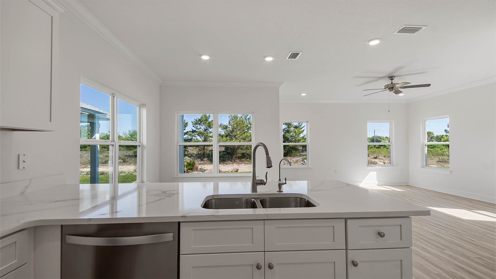 Kitchen with quartz countertops and white cabinets and stainless steel appliances and dining area.