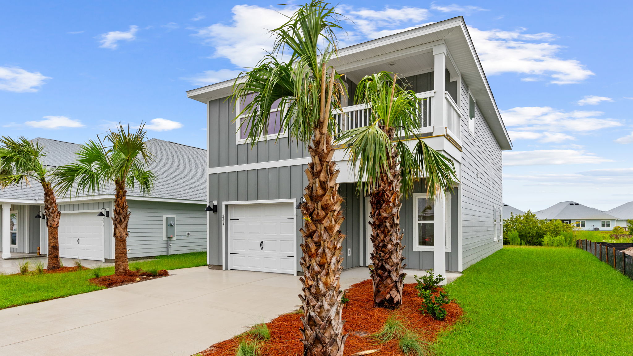 Monroe floor plan at WindMark Beach with Hardie siding and covered front porch and balcony and 1 car garage.