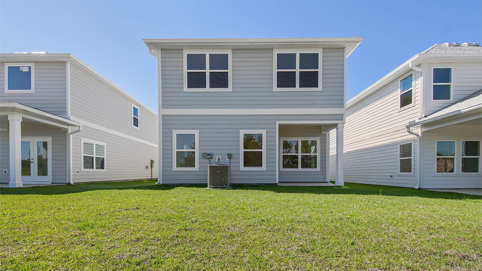 Monroe floor plan at WindMark Beach with Hardie siding and covered front porch and balcony and 1 car garage.