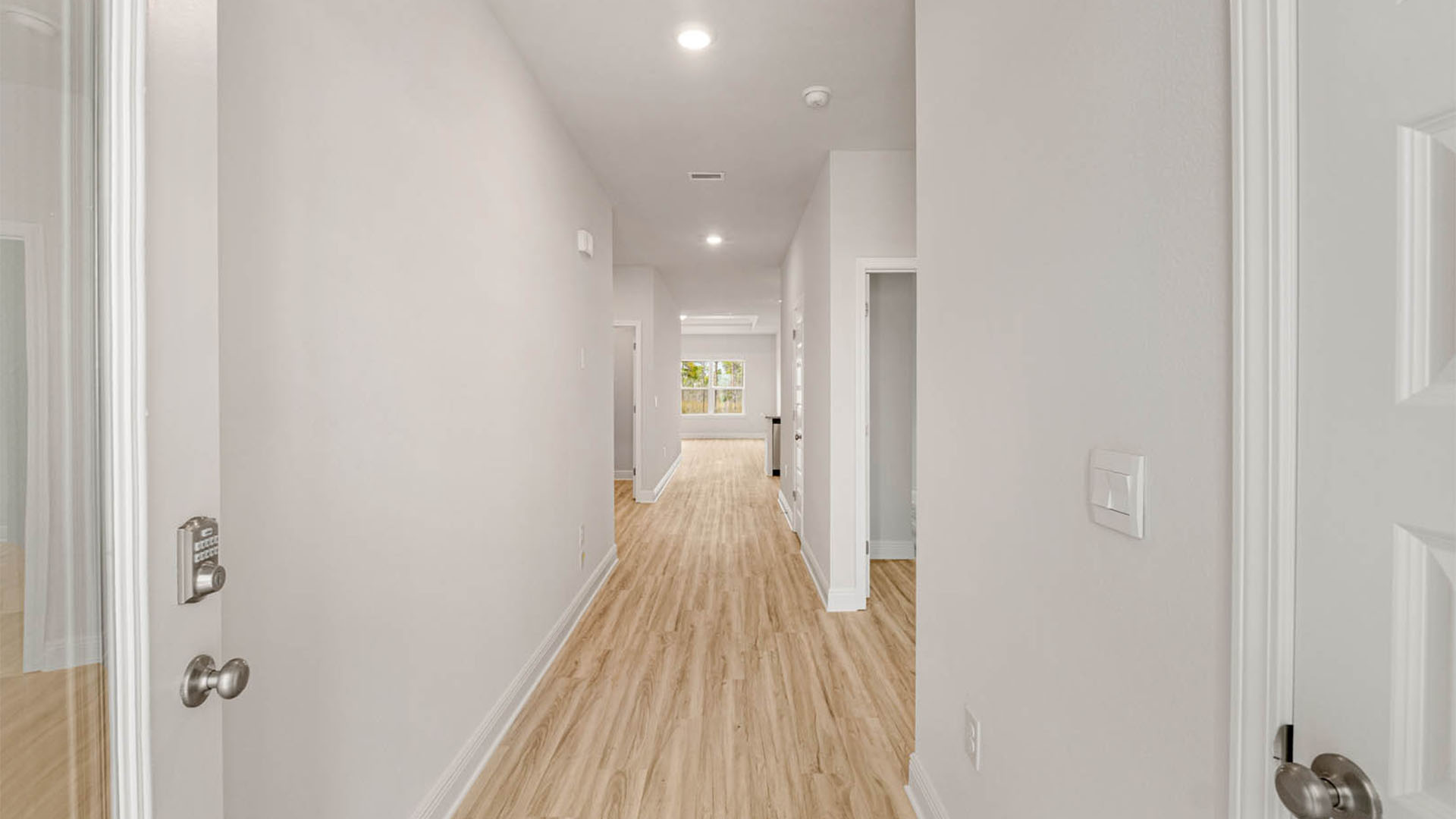 Front hallway with EVP flooring next to bedrooms and guest bathroom.