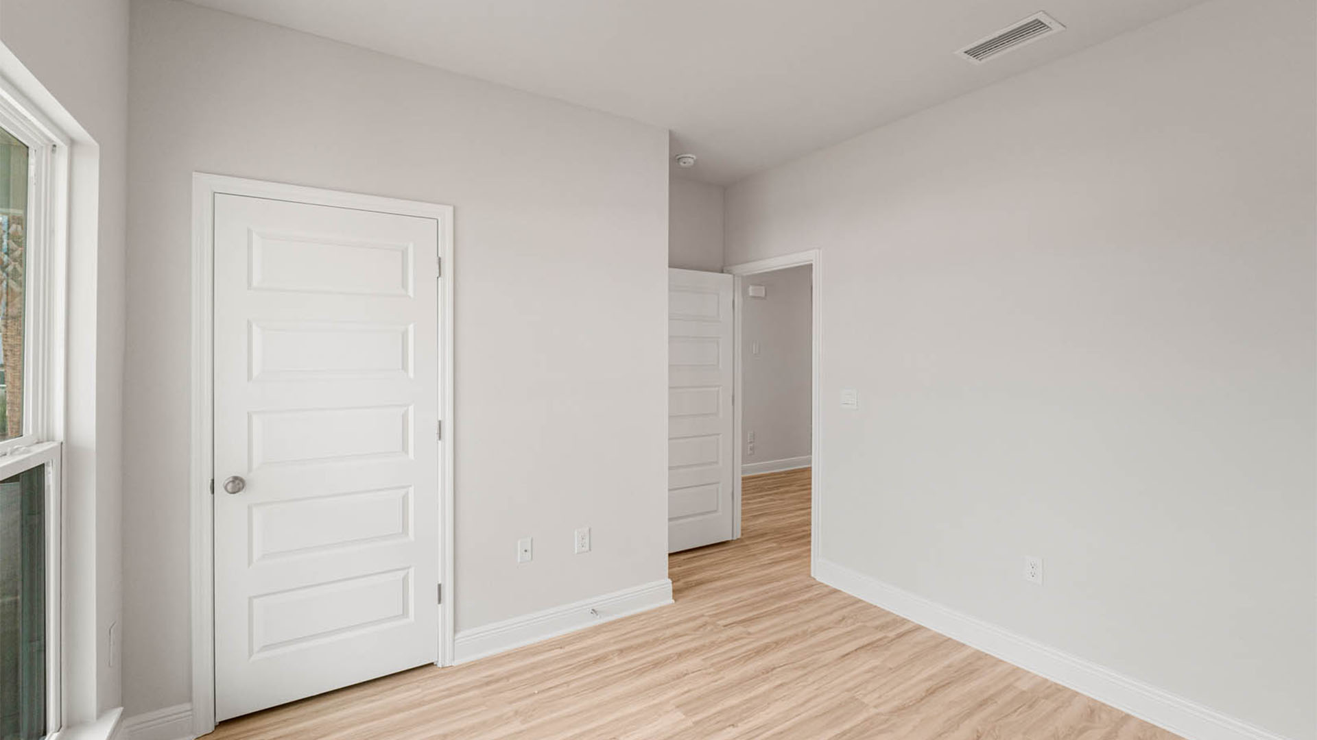 Bedroom with EVP flooring and closet.