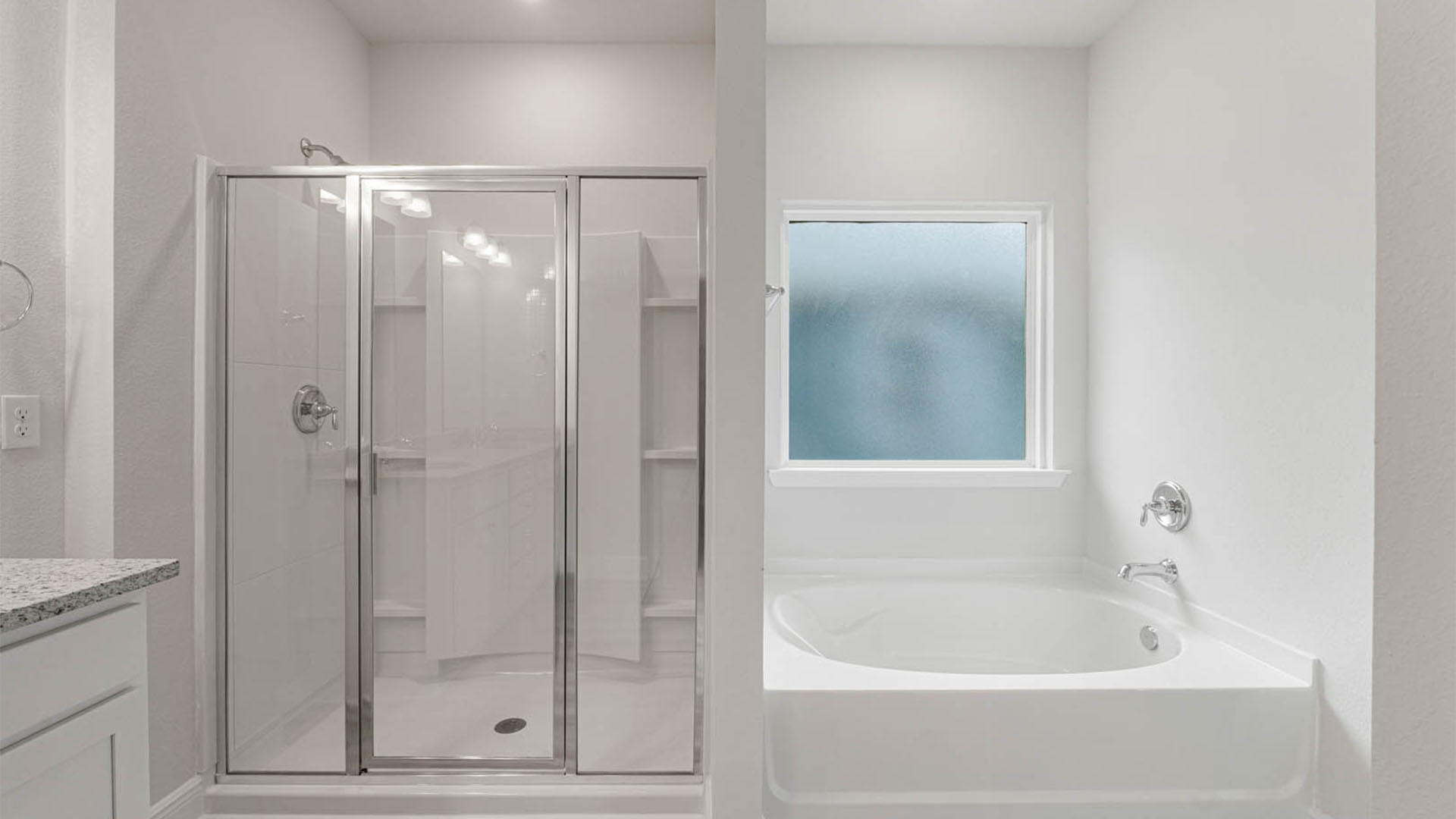 Primary bathroom with double vanity granite countertops and shower with glass door and separate tub and EVP flooring.