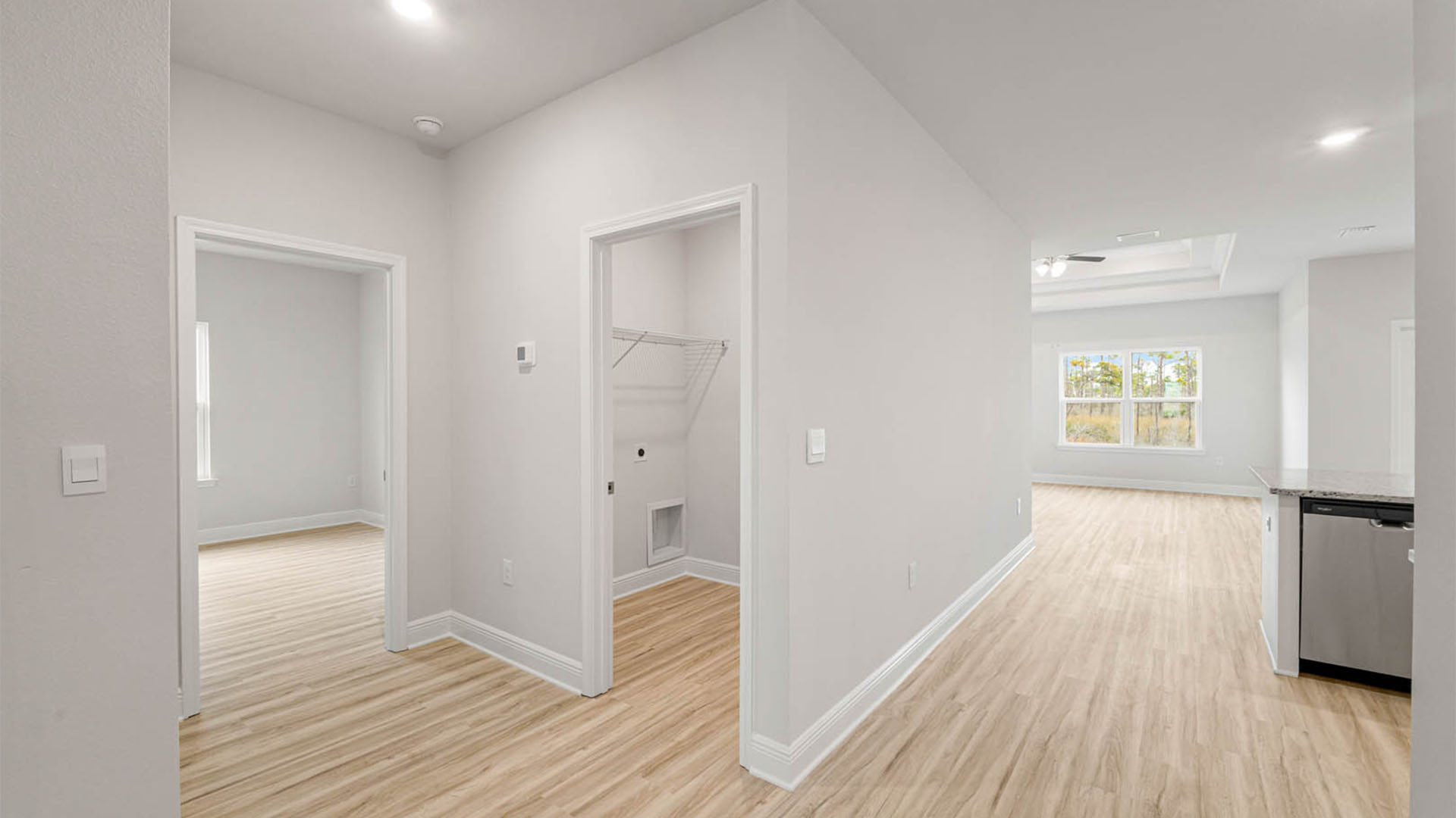 Hallway next to laundry room and bedroom and garage.