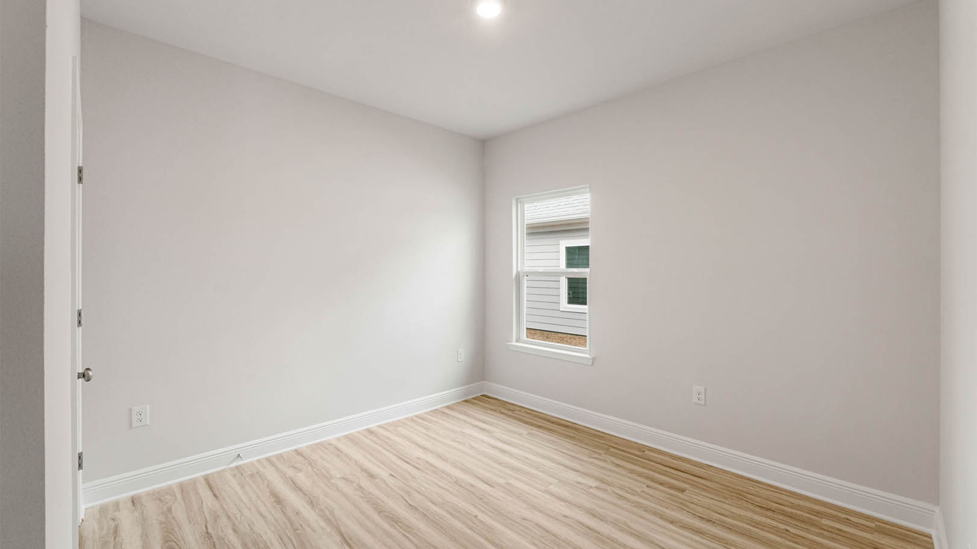 Bedroom with EVP flooring and window.