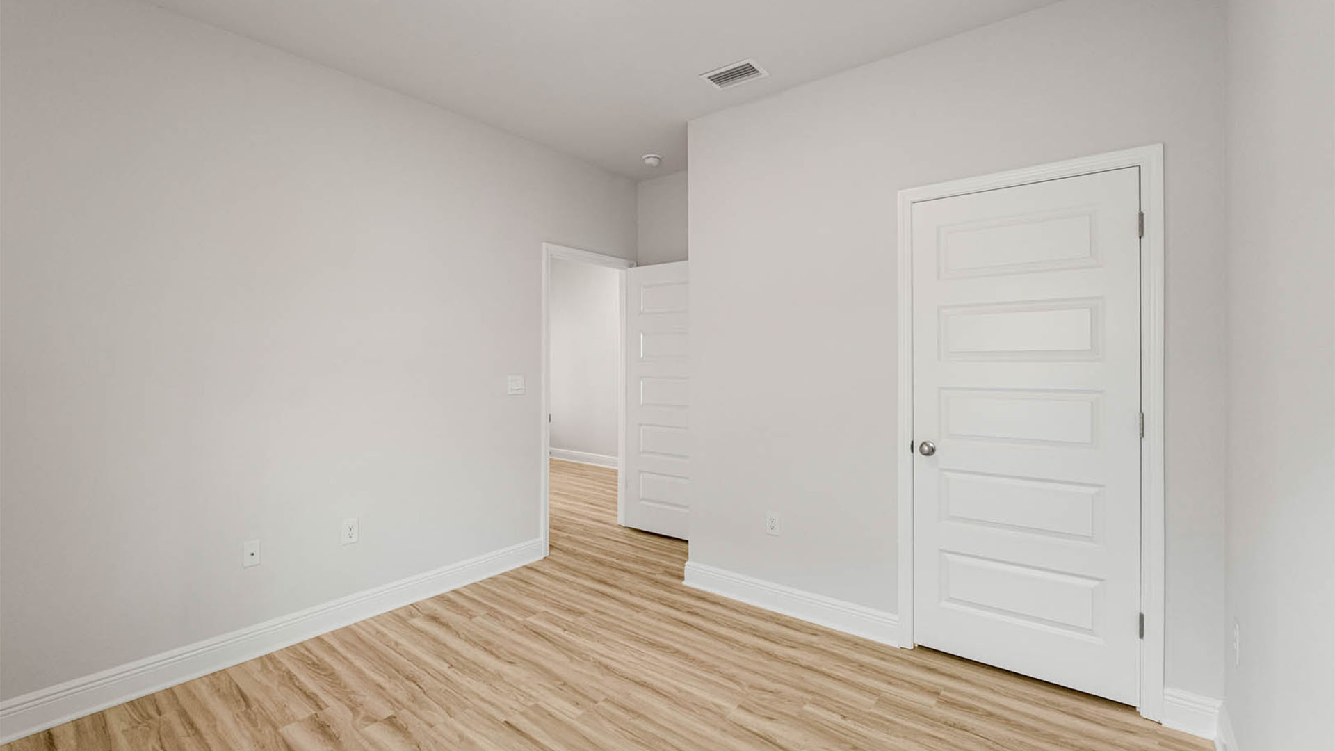 Bedroom with EVP flooring and closet.