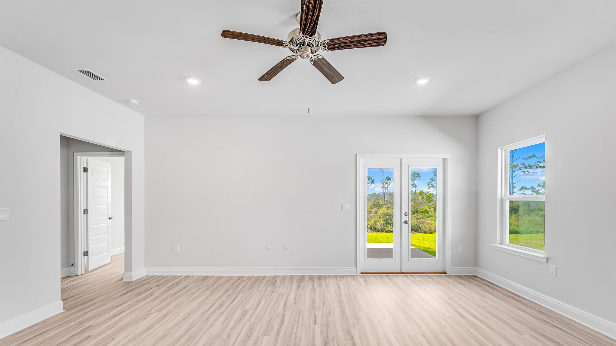 Living room with EVP flooring and ceiling fan and back door.