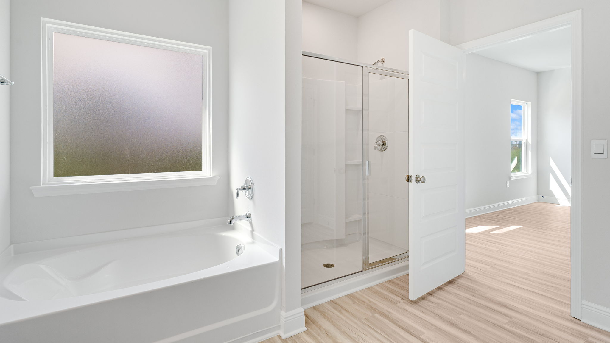 Primary bathroom with separate tub and shower with glass door.