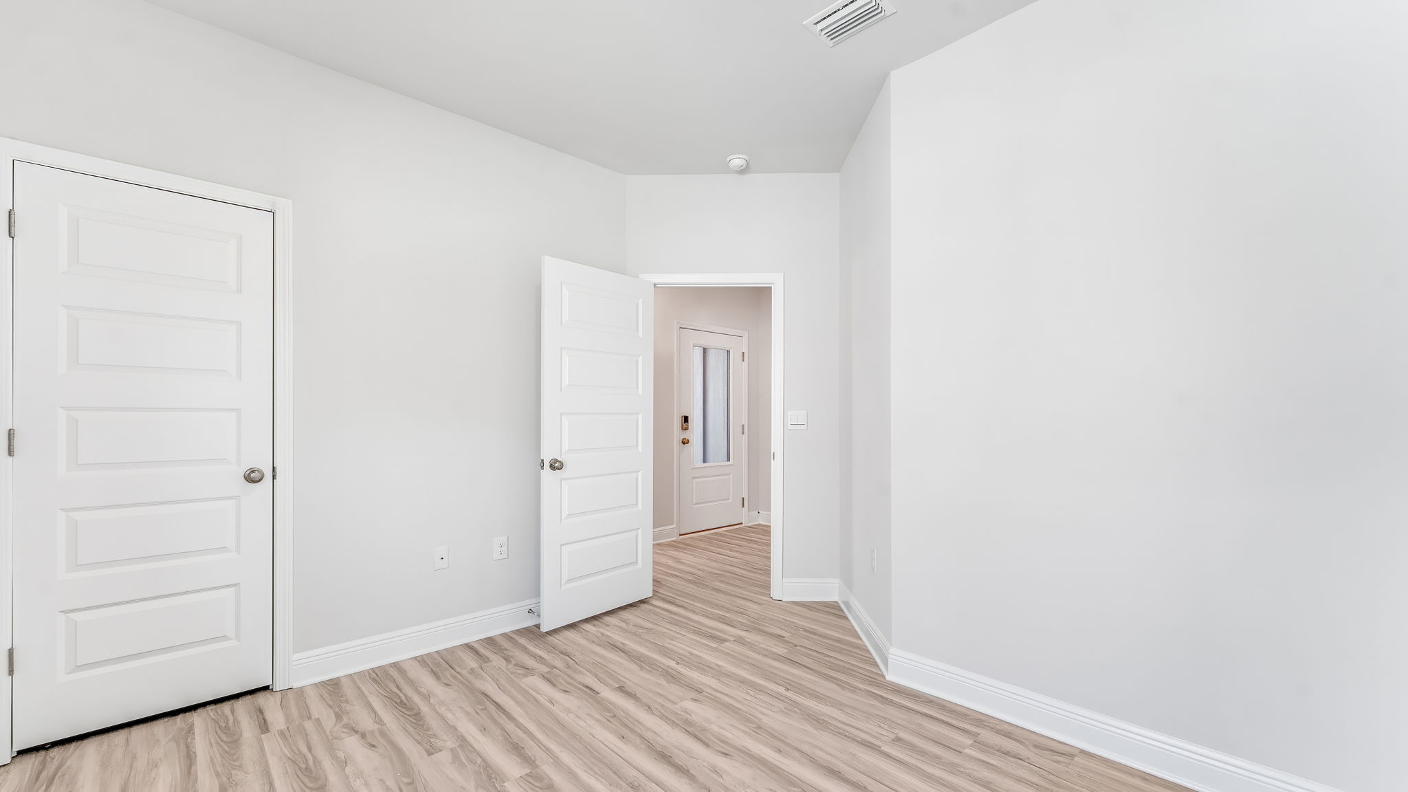 Bedroom with EVP flooring and closet.