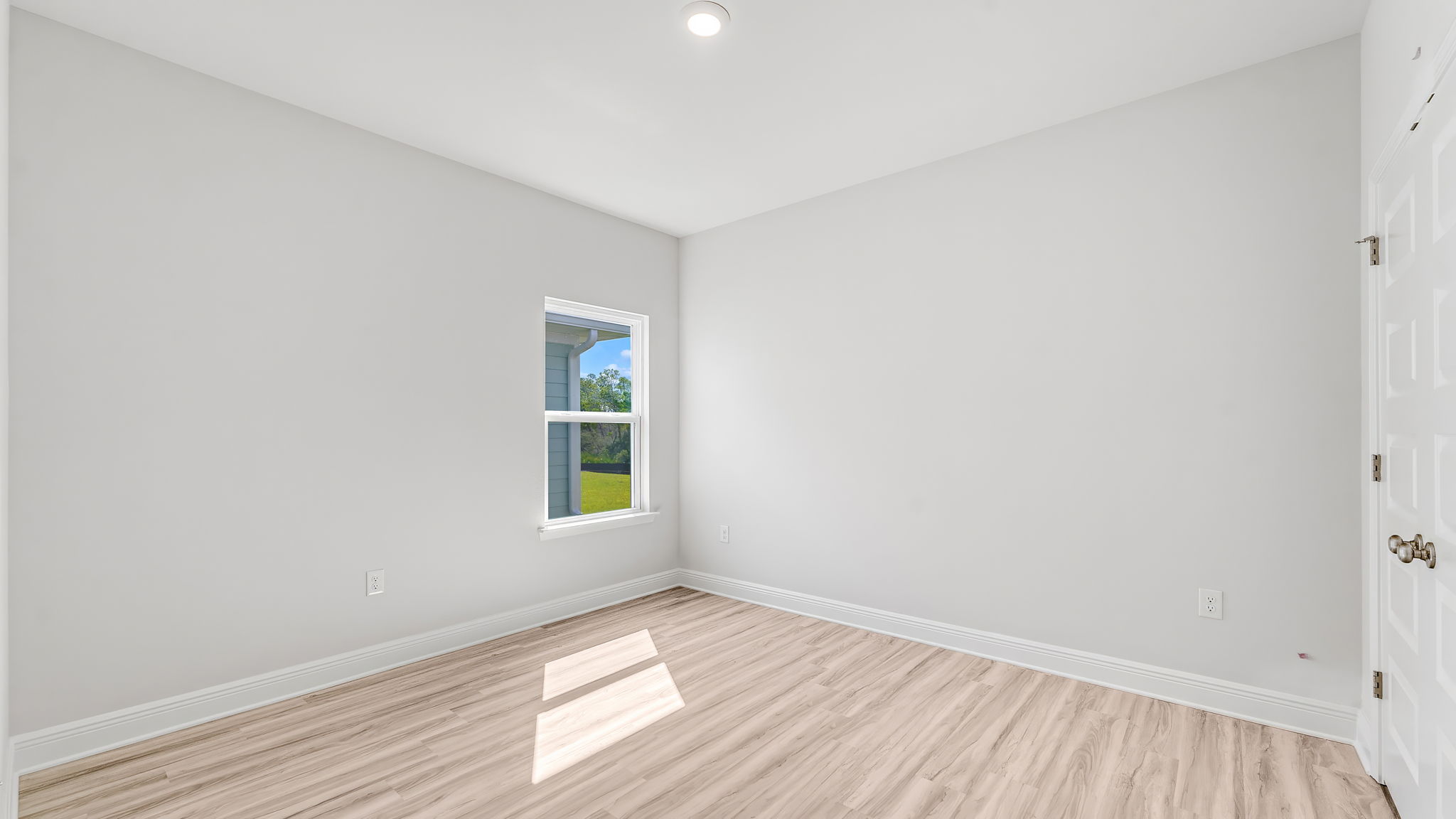 Bedroom with EVP flooring and window and closet.