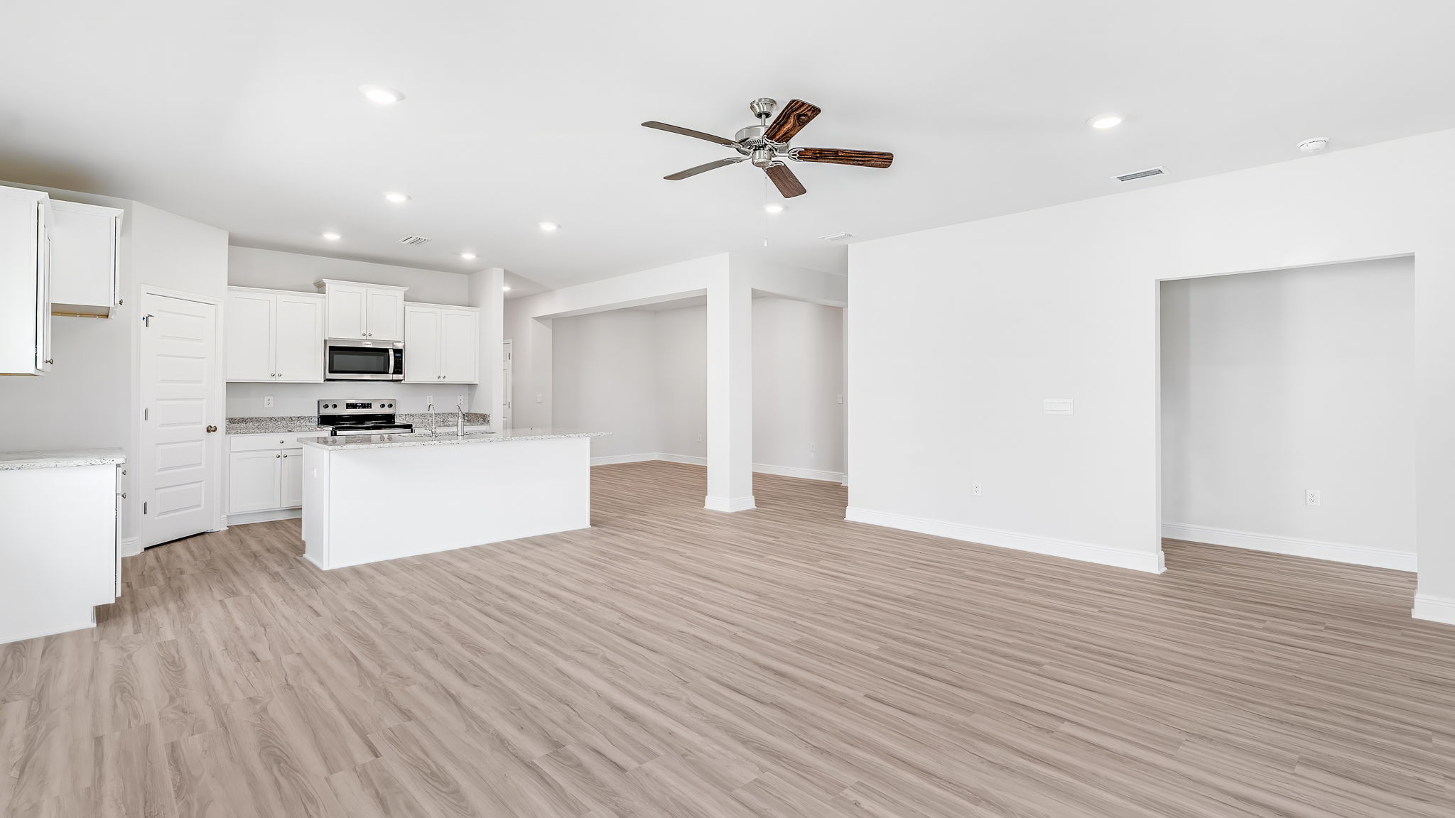 Living room with EVP flooring and ceiling fan and dining room.