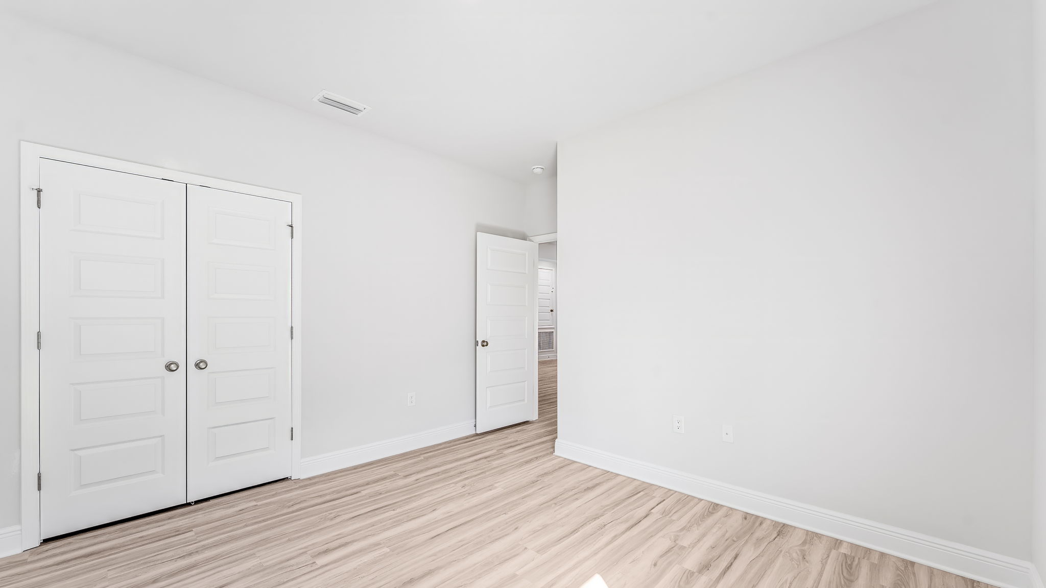Bedroom with EVP flooring and closet.