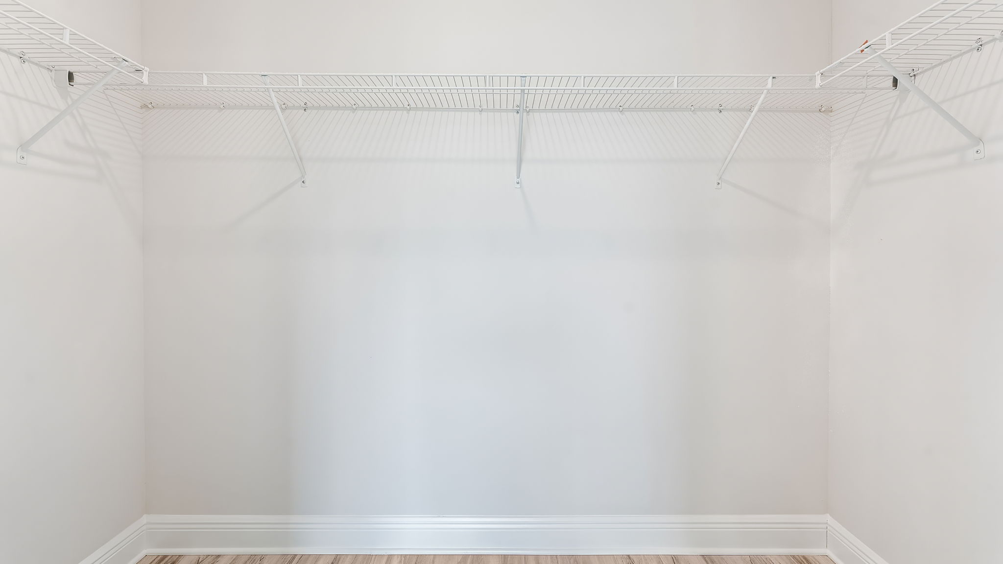 Primary bathroom closet with ventilated shelving.