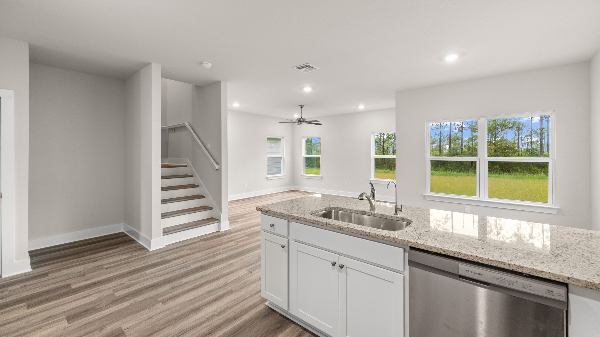 Kitchen with granite countertops and white cabinets and stainless-steel appliances.