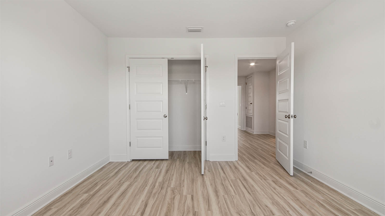 Bedroom with EVP flooring and closet.