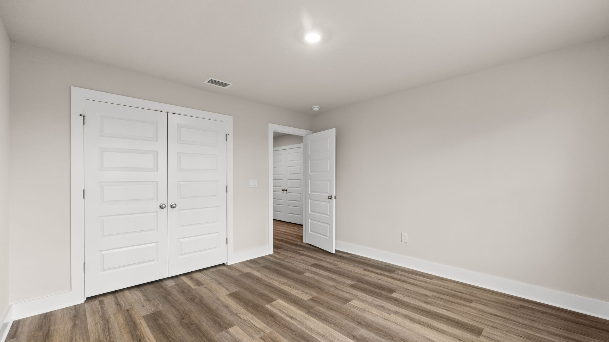 Bedroom with EVP flooring and closet.