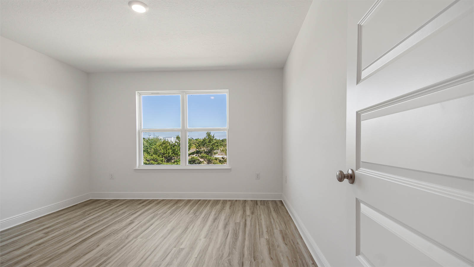Bedroom with EVP flooring and window.