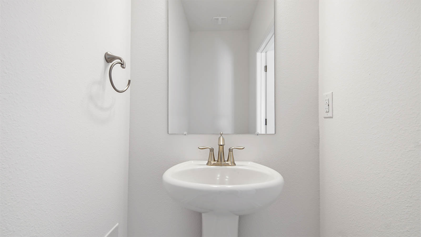 Half bathroom with sink and mirror.
