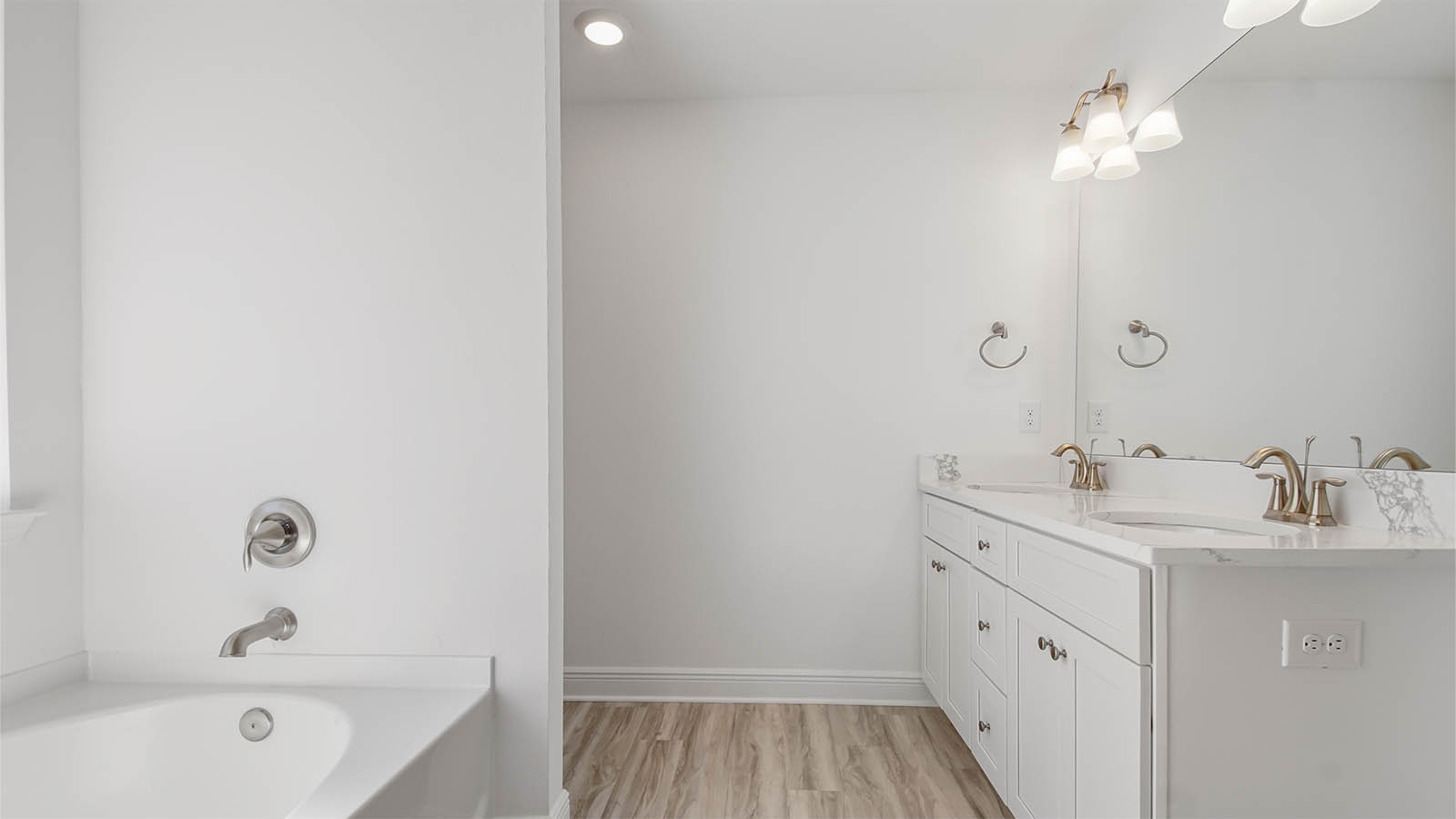 Primary bathroom with EVP flooring and double vanity quartz countertops and white cabinets.